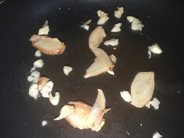 鍋子放入少少油，然後後把蒜頭及薑片放入爆香。