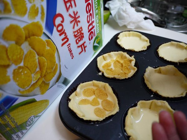 將完成的檸檬乳酪液倒入塔皮中,上層灑些雀巢玉米脆片,放入烤箱170度烤28分