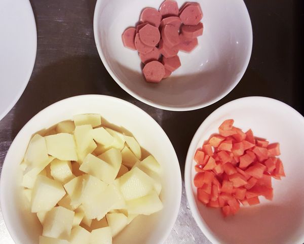 馬鈴薯跟紅蘿蔔切丁，熱狗切片，切一塊蒜頭爆香用