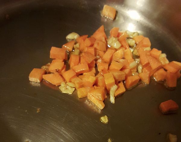 倒橄欖油將蒜頭爆香後，加入紅蘿蔔