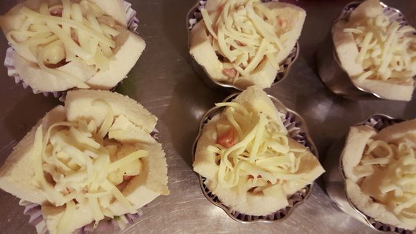 將白醬餡填入吐司杯，灑上焗烤起司絲，烤箱烤10分鐘至起司絲金黃