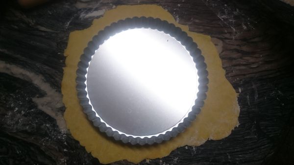 將8吋塔模放到擀開的麵團上，確認模型與鹹派皮麵團每邊都有2隻手指頭的寬度
(預留兩隻手指頭的寬度，有助於派皮可以順利放入模型內)