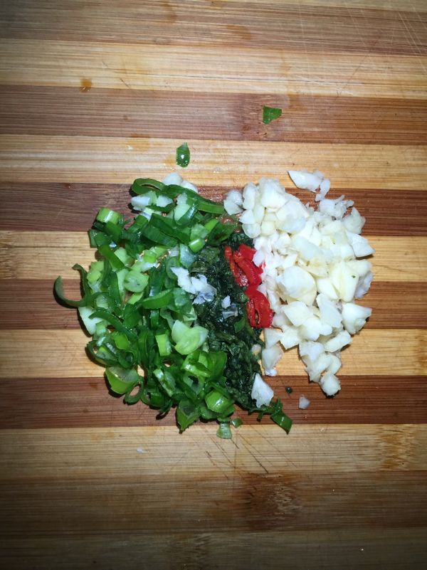 在同時把䓤、薑、蒜、香菜、辣椒切末等待調成五味醬。