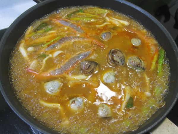 水滾後 加熱蝦子和蛤蠣 轉小火 蓋鍋蓋  等待蛤蠣熟透打開殼