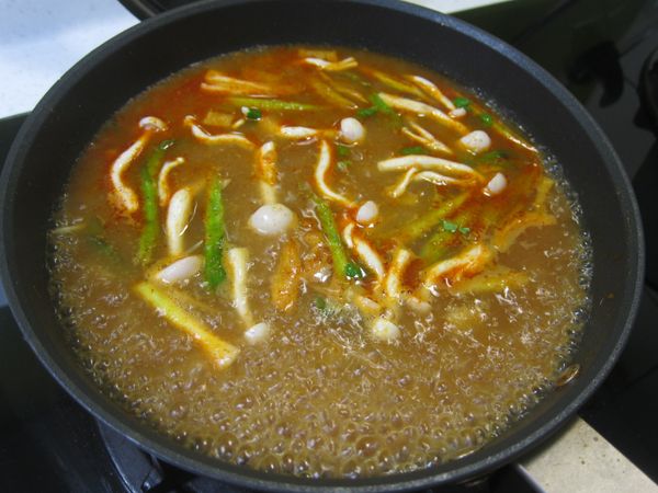 轉中火 加入雪白菇 和 毛豆仁 水煮開