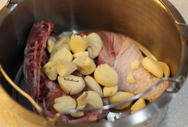 雞腿反面放入鍋內，將蒜頭均勻佈在雞腿上並倒入米酒。