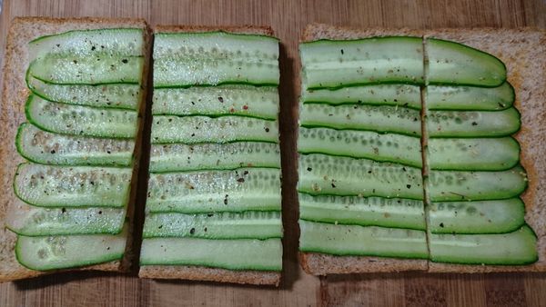 灑上彩虹胡椒後，將2片土司的中間切一刀，再將土司對切，吃早餐囉。