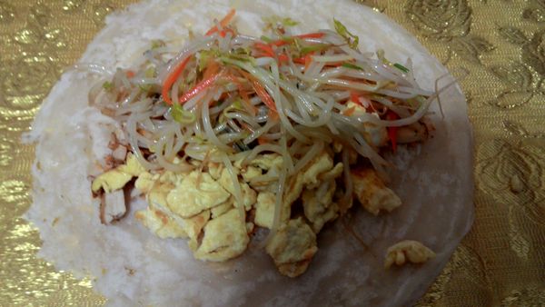 春捲皮舖上，先灑上花生粉再放其他的材料，包起來即可。