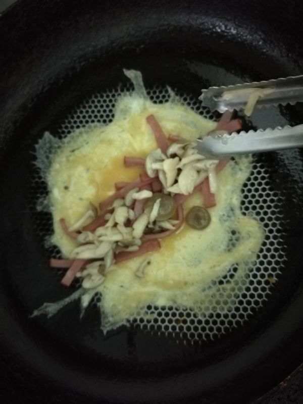 煎第一片蛋時
需先加一層火腿
再加一層香菇
再捲起來