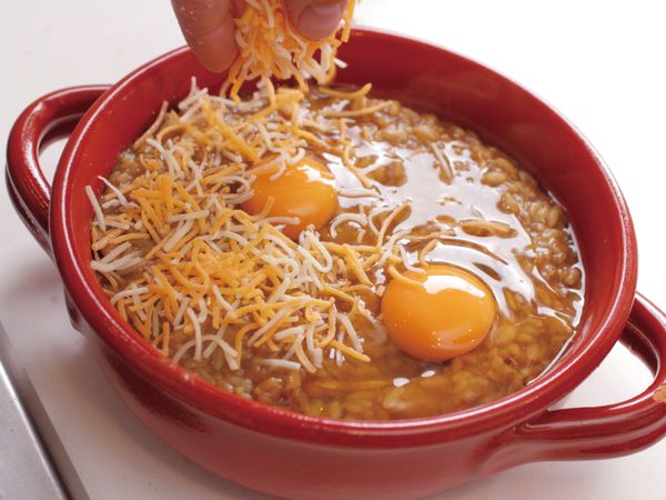 將12 盛入耐熱盤中。在中間打上蛋，鋪上乳酪絲，放上迷迭香。注意不要將蛋黃弄破，蛋黃上也要確實鋪上乳酪絲。