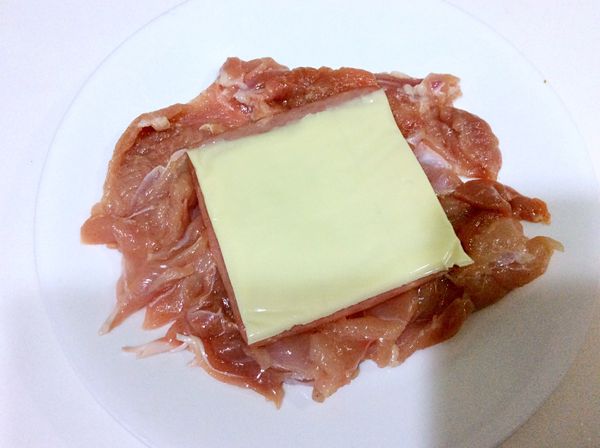 雞肉洗淨去筋，拍打幾下讓肉質鬆軟。表面塗抹鹽巴和胡椒粉醃製10分鐘。包上起司和火腿。