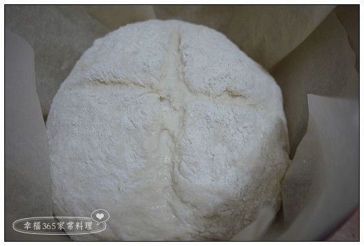 小心的在鑄鐵鍋中舖上料理紙，再把麵團放入。麵團表面的麵粉如果不夠多，再灑上一些，然後用刀子割出喜歡的刀紋。送進烤箱以200℃加蓋烤約30分鐘，之後戴隔熱手套取出蓋子，再繼續烤約30分鐘，直到表面上色。