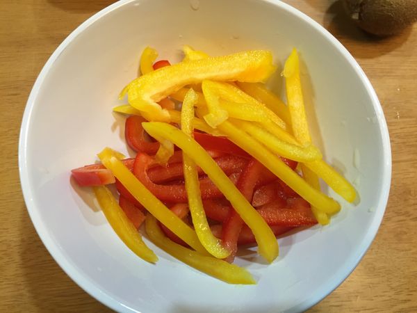 紅、黃椒各約4分之1顆切條狀，方才製作的橙汁可取一半倒入切條彩椒中抓勻，放一旁備用並等待橙汁吸收入味。（彩椒儘量能浸在橙汁中，或是適時翻動，讓上面浸不到橙汁的彩椒能置底吸汁）