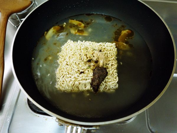 水滾後下味味麵與所有的調味包，煮至麵熟