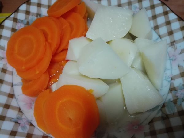 將馬鈴薯、紅蘿蔔切小塊，放入蒸盤，外鍋一杯水，蒸熟備用。