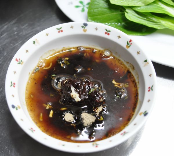 用煮麵的湯拌勻醬包和調味料，淋在麵條上拌勻。