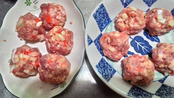 取適量肉饀放在手掌中壓平，包入鵪鶉蛋搓成球狀.要壓一下.讓空氣跑出來.將搓好的肉丸先均勻地裹上麵粉→蛋液→麵包粉