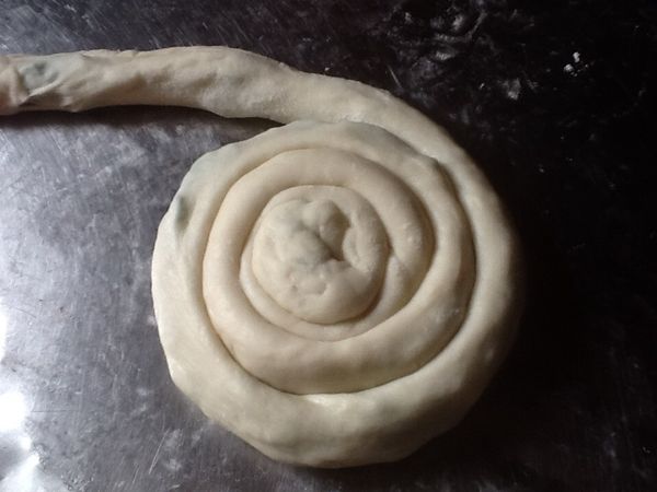 9.再由一端向內捲，捲成螺旋狀，完成後可稍壓扁至約1.5cm厚度
   (煎時較易熟)。