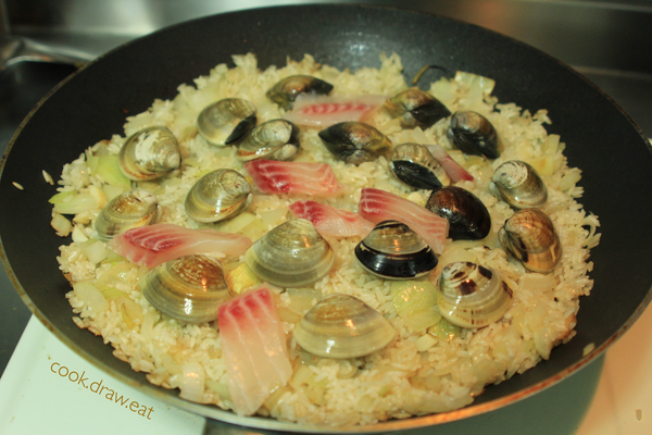 ［燉飯］米炒到沾滿奶油呈現淺黃色後，轉小火。將米飯鋪平在鍋中，在米飯上鋪上蛤蠣、鯛魚，並加入600c.c.的高湯（約2碗），加鍋蓋悶煮10分鐘。悶煮10分鐘後，開鍋蓋放入燙熟的透抽，加入剩餘的高湯，再以小火悶煮10分鐘。（前後共20分鐘）