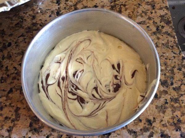 8吋圓模底部先鋪上烘焙紙，旁邊不需抺油。先倒部份的麵糊，再用湯匙舀些可可麵糊隨意的在表面撒上數點，再用筷子劃開，就呈現紋路。