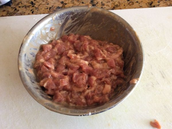 夾心肉切成小丁，用醬油、少許鹽、胡椒粉抓拌勻，打一些水，摔打一下，待水分被肉吸收後再放半個蛋及太白粉拌勻，加少許沙拉油，醃約20分鐘。