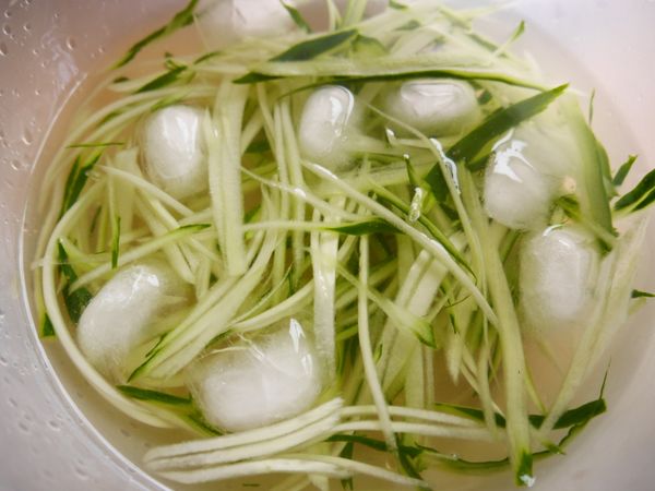 先把小黃瓜刨絲後泡冰水，撈起瀝乾放入盤中備用