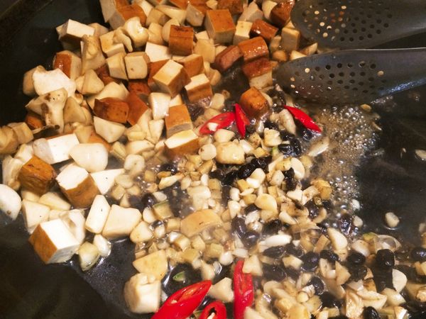 香氣出來後，跟食材混合炒勻，加入調味料，醬油，蠔油，糖，少量清水，拌炒到醬汁收