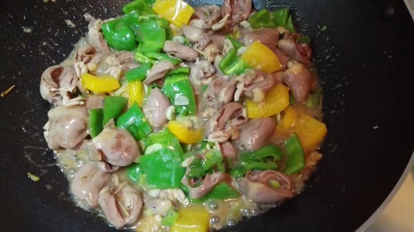 下青椒、黃椒、蔥綠，翻炒均勻，調味後即可盛盤。