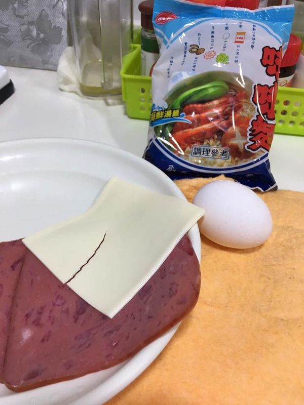 將蛋打散拌入瀝乾的味味麵及火腿塊，加少許的鹽巴、胡椒調味，拌勻