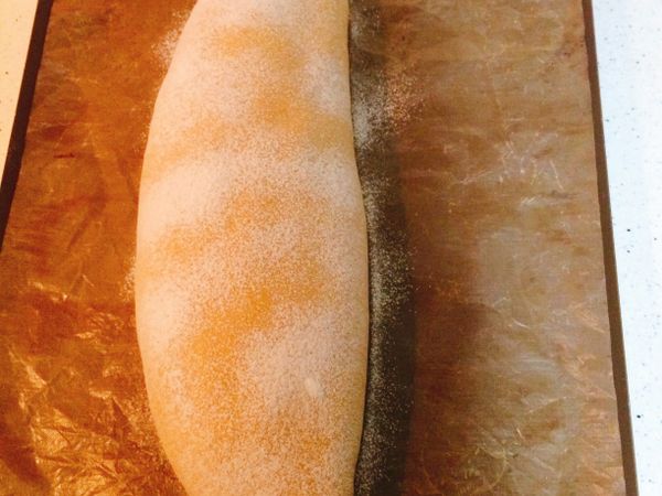 1）發酵完成前10分鐘先將麵糰取出，將烤箱預熱至170度。
2）在麵糰表面篩上ㄧ層薄薄的高筋麵粉。