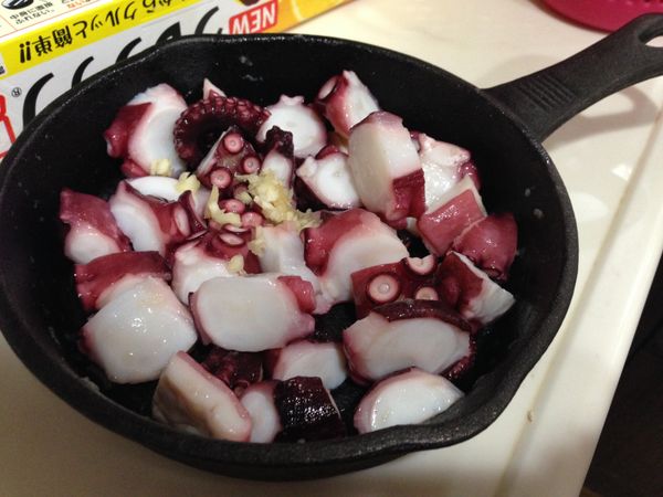 橄欖油放入小鍋中,加入蒜末、紅辣椒片(不吃辣可省),中火加熱,油熱了後再放入章魚塊和蘑菇(對切)