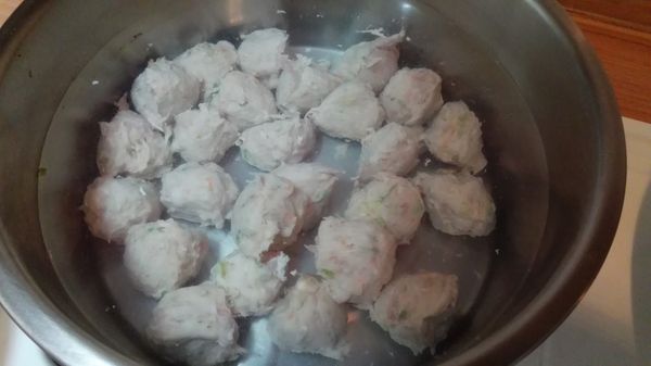 起一鍋水，燒至60度關火；將鮮肉魚漿，抓揑成圓球狀，放入溫水中。