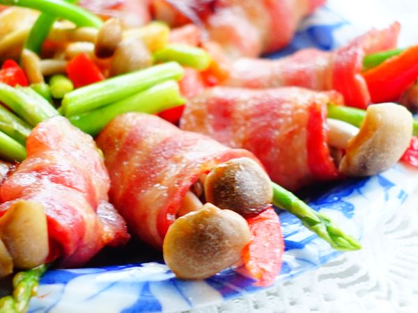 將培根對切，再將鴻喜菇，蘿筍，紅甜椒放入在培根中，再緩緩的將培根捲起來備用。