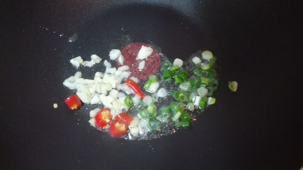 起油鍋，下蒜末、蔥花、辣椒爆香。