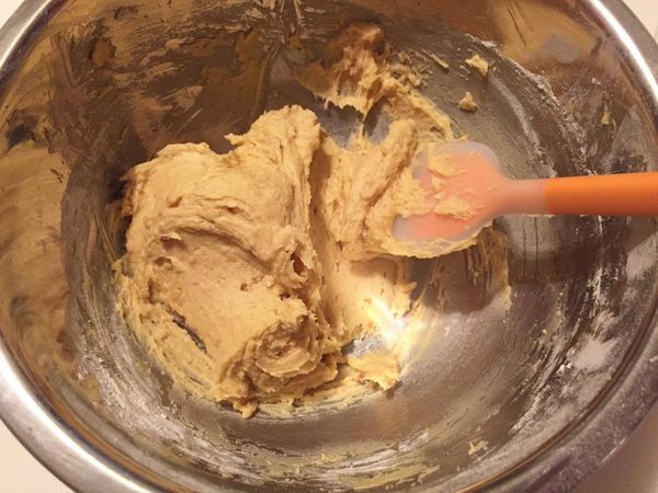 分次加入過篩後的麵粉和泡打粉，用刮刀慢慢壓拌混合至沒有粉末狀