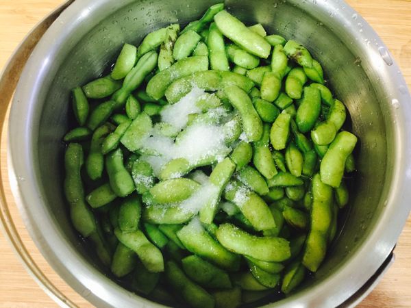 毛豆用鹽搓洗去除表面的毛質，洗淨瀝乾。