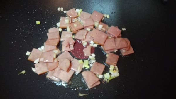 起油鍋，下蔥白爆香，再放入火腿片炒軟。
