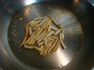 將吃剩薯條倒入熱油鍋中煎香