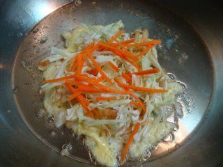 在蛋液上鋪上高麗菜與紅蘿蔔絲
