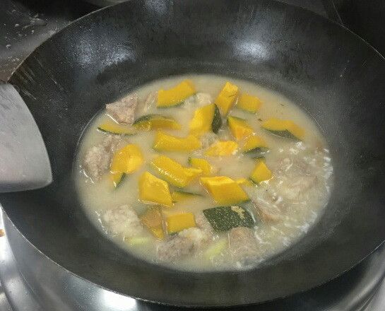 再放入南瓜一起拌炒, 加入淹過食材的水，先蓋鍋燜煮約15分鐘