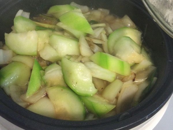 豬肉片熟了之後夾到麵線上備用，放入絲瓜繼續拌炒再悶一下，可以不用放水，絲瓜會出一點水。接著放米酒、烹大師調味。