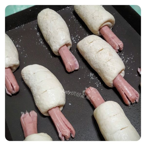 進烤箱前在麵團上噴水撒上適量的起司粉，起司粉我只撒了4顆，接著在麵團上劃上三刀