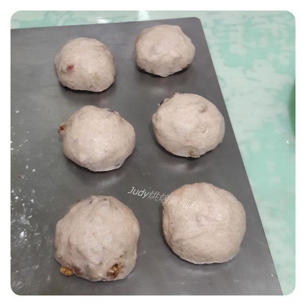 將第一次發酵好的麵團移出到桌面，麵團中的空氣用手壓下去擠出來 ， 分割成6個麵團，分別滾圓，蓋上保鮮膜休息20分鐘