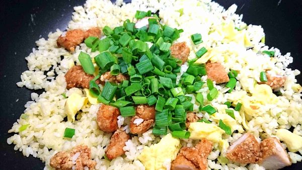 加葱白、炒蛋、鹽酥雞和葱綠：將「步驟4的葱白」、「步驟5的炒蛋」和「步驟6的鹽酥雞」加進來，放入葱綠，拌炒一下。