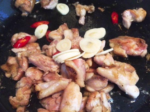 雞肉煎過，鍋裡就會有油脂，這時再下蒜片，辣椒炒出香氣