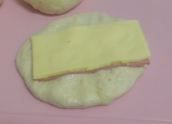 將麵團壓扁，放上一份材料，捲起收邊