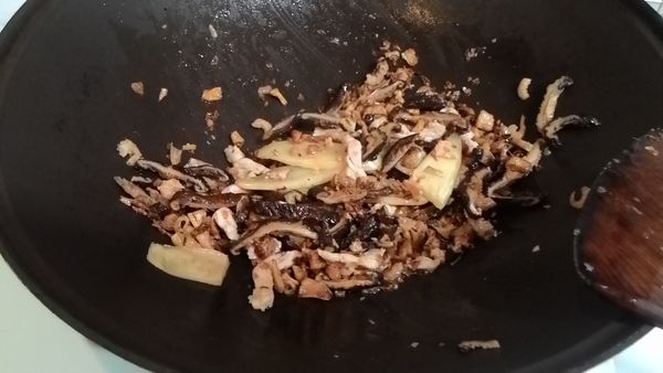 肉絲先下鍋炒至半熟，再下香菇絲，蝦米，蒜頭酥拌炒。