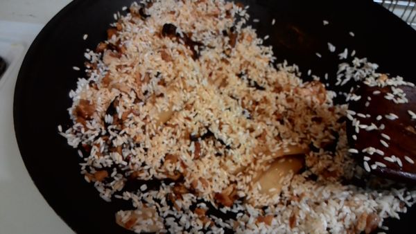 加入米及醬油，塩，拌勻使米上色，這時已有陣陣香氣。