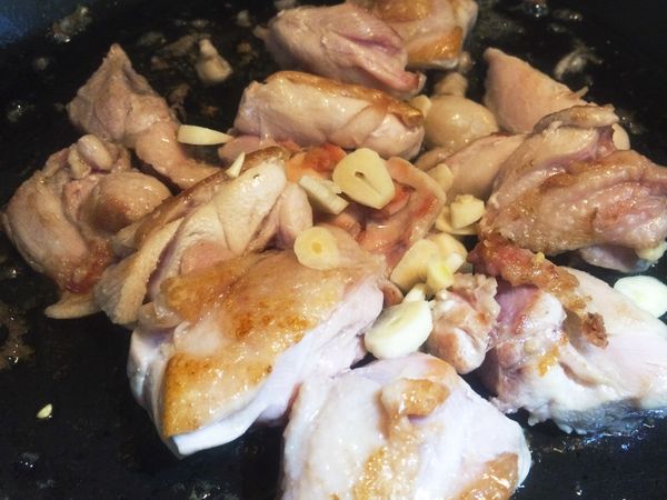 皮面煎金黃後翻面，讓另一面也煎到微黃上色，肉都煎好後，加入蒜片炒出香氣