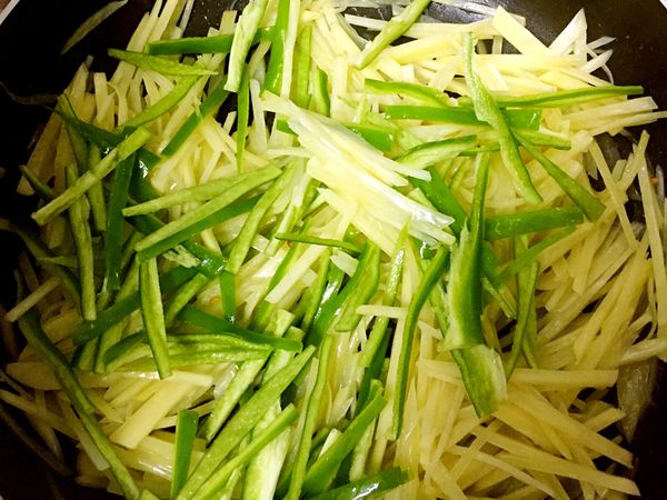 馬鈴薯炒到軟後，加入青椒一起炒，加入調味料拌炒即可完成